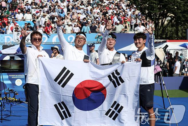 대한민국 양궁대표팀 김우진, 김제덕, 이우석, 박성수 감독이 30일(한국시간) 프랑스 파리 앵발리드에서 열린 2024 파리올림픽 양궁 남자 단체전 결승 프랑스와의 경기에서 금메달을 획득한 후 손가락 세개를 펴 보이며 3연패를 알리고 있다. 2024.7.30/뉴스1 ⓒ News1 박정호 기자