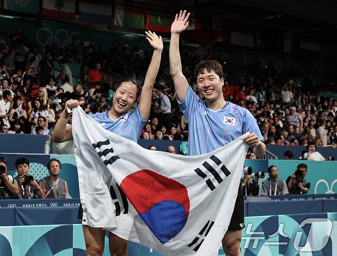 대한민국 탁구 대표팀 신유빈, 임종훈 선수가 30일(한국시간) 프랑스 파리 사우스 파리 아레나4에서 열린 '2024 파리올림픽' 탁구 혼합복식 홍콩 과의 동메달 결정전 경기에서 동메달을 확정지은 후 태극기를 들어보이고 있다. 2024.7.30/뉴스1 ⓒ News1 이동해 기자