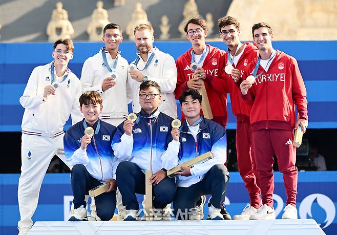 남자 양궁 대표팀의 김제덕(아래 왼쪽부터), 김우진, 이우석이 30일(한국시간) 프랑스 파리 앵발리드에서 열린 2024 파리올림픽 양궁 남자 리커브 단체 결승전에서 프랑스를 꺾고 금메달을 딴 뒤 2위 프랑스, 3위 튀르키예 선수들과 기념촬영을 하고 있다. 한국 남자 양궁은 올림픽 3연패를 달성했다. 2024. 7. 30.  파리 | 박진업 기자 upandup@sportsseoul.com