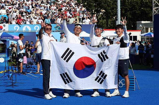 29일(현지시간) 프랑스 파리 레쟁발리드 양궁 경기장에서 열린 2024 파리 올림픽 양궁 남자 단체 결승전 한국과 프랑스의 경기. 금메달을 차지한 한국 대표팀 선수들이 태극기를 들고 세리머니를 하고 있다. [연합]