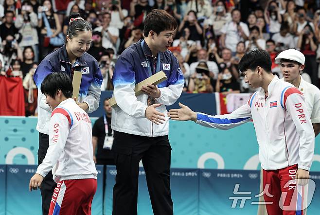 대한민국 탁구 대표팀 신유빈, 임종훈 선수가 30일(한국시간) 프랑스 파리 사우스 파리 아레나4에서 열린 '2024 파리올림픽' 탁구 혼합복식 시상식에서 은메달을 획득한 북한 김금용, 리종식 선수에게 축하 받고 있다. 2024.7.30/뉴스1 ⓒ News1 이동해 기자