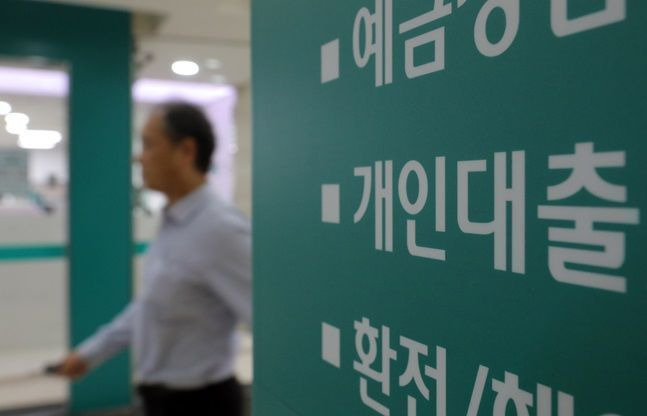 서울 한 시중은행의 대출 창구 안내문 옆으로 사람이 지나가고 있다.ⓒ뉴시스