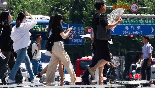 폭염 경보가 발효 중인 지난 29일 대구 중구 공평네거리에서 시민들이 지열로 인한 아지랑이가 피어오르는 도로를 지나가고 있다. 대구/연합뉴스