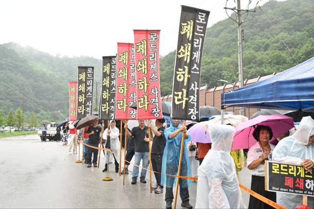 지난달 29일 경기 포천시 미8군 로드리게스 사격장 앞에서 우비를 입은 포천시민들이 사격장 폐쇄를 촉구하는 플래카드를 들고 집회를 열고 있다. 포천시사격장 등 군관련시설 범시민대책위원회 제공