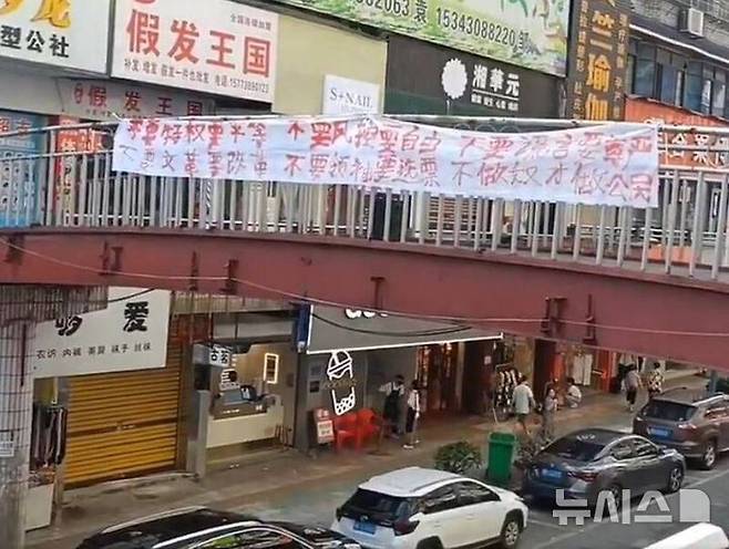 [베이징=뉴시스] 중국 후난성에서 시진핑 체제에 반대하는 시위가 벌어졌다고 대만 자유시보가 31일 보도했다. 사진은 지난 30일 후난성 궈디시 신화현의 한 육교 양쪽에 붉은색 글씨가 적힌 흰색 현수막이 내걸린 동영상이 소셜미디어 플랫폼 엑스(X·옛 트위터)한 장면.(사진=대만 자유시보 갈무리) *DB 및 재판매 금지 2024.7.31 photo@newsis.com