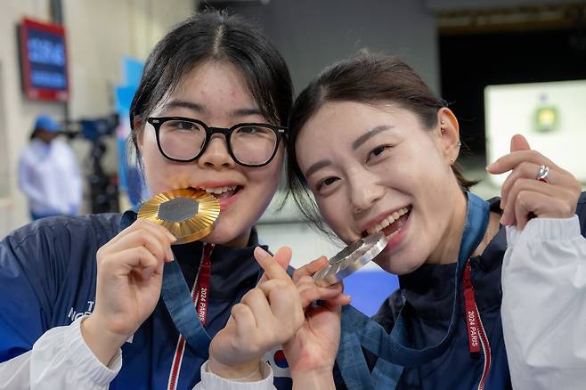 28일(현지시각) 2024파리올림픽 사격 여자 10m 공기권총 시상식에서 금, 은메달을 획득한 오예진과(왼쪽) 김예지가 메달을 깨물며 손하트를 보이고 있다. /올림픽사진공동취재단