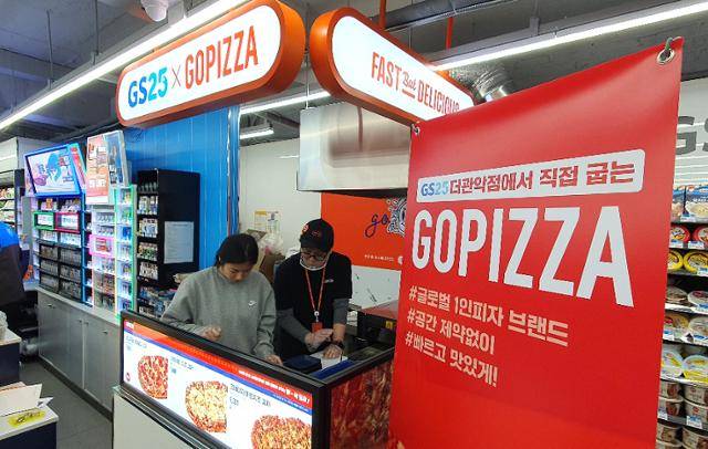 서울시 관악구 GS25 더관악점에서 직원들이 전용 오븐을 이용해 '고피자'를 조리하고 있다. GS25 제공