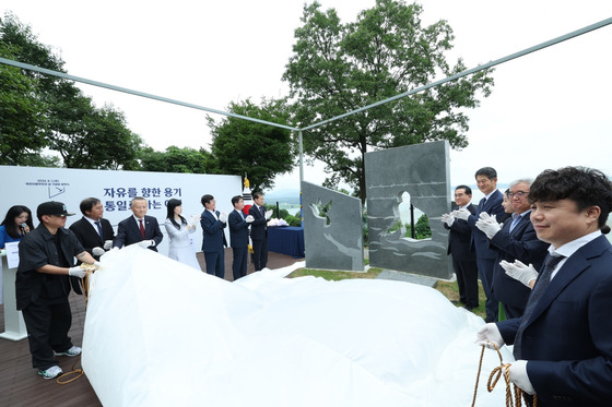 A monument to commemorate North Korean defectors who lost their lives trying to escape the regime is unveiled at a ceremony in Paju, Gyeonggi, near the inter-Korean border on Thursday. Unification Minister Kim Yung-ho, Peaceful Unification Advisory Council Secretary-General Tae Yong-ho and some 60 defectors attended the ceremony. [YONHAP]