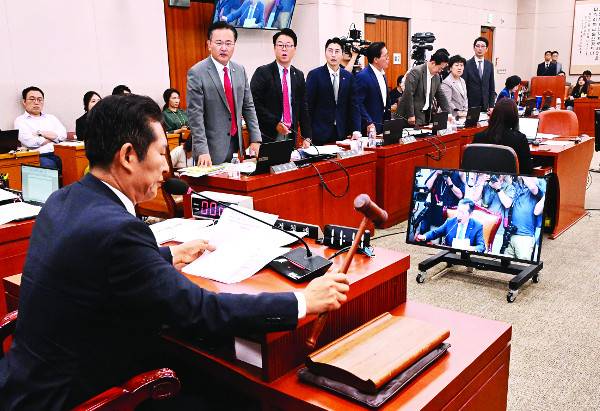 정청래 국회 법제사법위원회 위원장이 31일 서울 여의도 국회에서 법사위 전체회의를 열고 의사봉을 두드리고 있다. 여당 의원들은 ‘전국민 25만원 지원법’과 ‘노란봉투법’이 법사위를 통과하자 정 위원장에게 “입법 독재”라고 항의했고, 정 위원장은 “퇴거 명령을 하겠다”고 맞받았다. 이병주 기자