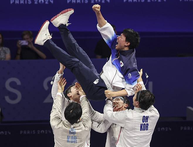 원우영 한국 펜싱 남자 사브르대표팀 코치가 1일 프랑스 파리 그랑 팔레에서 열린 2024 파리올림픽 펜싱 사브르 남자 단체 헝가리와 결승에서 승리해 올림픽 3연패를 달성한 뒤 선수들로부터 헹가래를 받고 있다. 연합뉴스