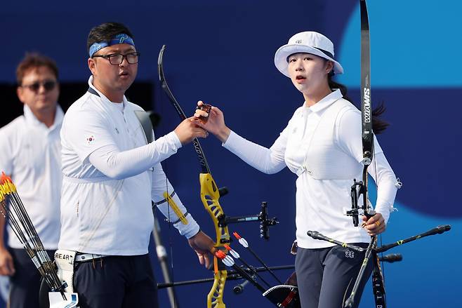 김우진(왼쪽)과 임시현이 2일 프랑스 파리 앵발리드에서 열린 2024 파리 올림픽 양궁 혼성 단체 16강 대만과의 경기 시작에 앞서 하이파이브를 하고 있다. /뉴시스