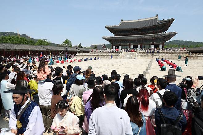 지난 5월1일 서울 경복궁을 찾은 시민들과 관광객들이 근정전 앞에서 열리는 궁중 일상재현 프로그램 ‘하루를 여는 세종’ 공연을 관람하고 있다. 연합뉴스