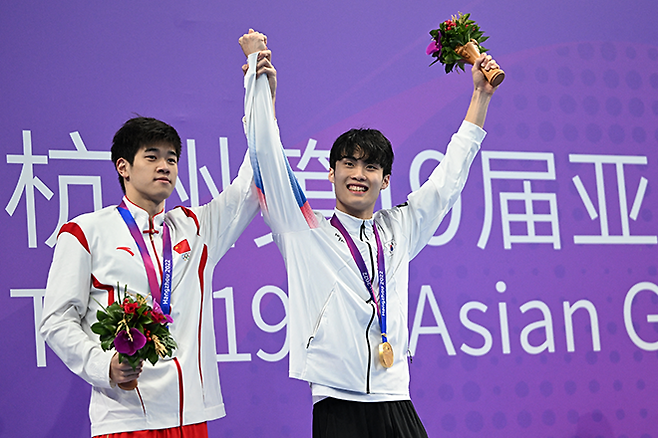 판잔러(왼쪽)가 항저우아시안게임 남자수영 자유형 200m 은메달 시상식에서 금메달리스트 황선우를 예우하고 있다. 사진=AFP=연합뉴스 제공