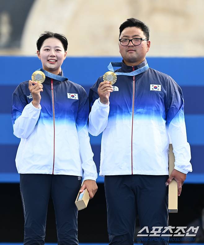 김우진과 임시현이 2일(한국시간) 프랑스 파리 레쟁발리드에서 열린 파리올림픽 양궁 혼성단체전 결승에서 독일을 제압하며 금메달을 차지했다. 박성수 감독, 임시현, 김우진이 태극기를 들고 올림픽 2연패를 뜻하는 손가락 2개를 들어보이고 있다. 파리(프랑스)=정재근 기자 cjg@sportschosun.com/2024.8.2/