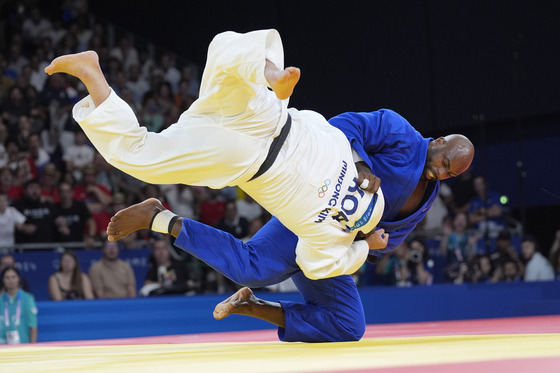 Korea's Kim Min-jong and France's Teddy Riner compete during their men's 100-kilogram final at Champ-de-Mars Arena in Paris on Friday.  [AP/YONHAP]