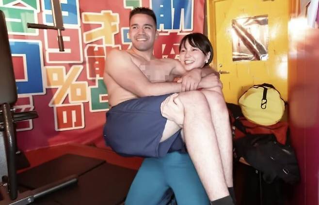 근육질의 젊은 여성 종업원들이 손님에게 ‘공주님 안기’를 해주고 있는 모습.&nbsp;SCMP 보도화면 갈무리