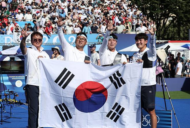 대한민국 양궁대표팀 김우진, 김제덕, 이우석, 박성수 감독이 30일(한국시간) 프랑스 파리 레쟁발리드에서 열린 2024 파리올림픽 양궁 남자 단체전 결승 프랑스와의 경기에서 금메달을 획득한 후 손가락 세개를 펴 보이며 3연패를 알리고 있다. /뉴스1