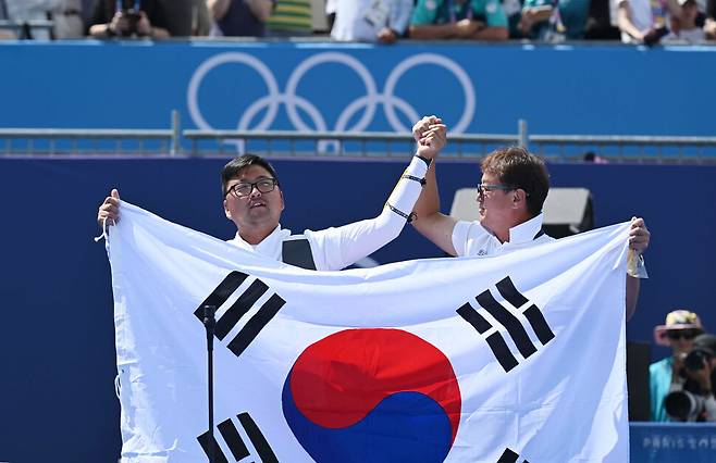 김우진이 4일(현지시각) 프랑스 파리 앵발리드에서 열린 2024 파리올림픽 양궁 남자 개인 결승에서 금메달을 확정 짓고 태극기를 들고 있다. 파리/올림픽사진공동취재단