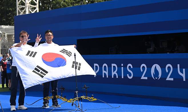 김우진이 4일(현지시각) 프랑스 파리 앵발리드에서 열린 2024 파리올림픽 양궁 남자 개인 결승에서 금메달을 확정 짓고 태극기를 들고 있다. 파리/올림픽사진공동취재단