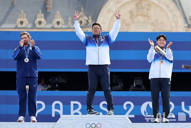 [파리=뉴시스] 김진아 기자 = 김우진이 4일(현지시각) 프랑스 파리 레쟁발리드에서 열린 2024 파리 올림픽 양궁 남자 개인전 시상식에서 시상대에 오르며 두 팔을 들어올리고 있다. 2024.08.04. bluesoda@newsis.com