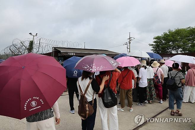 '양산 행렬' (파주=연합뉴스) 임병식 기자 = 폭염이 기승을 부린 30일 경기도 파주시 임진각에서 외국인 관광객들이 양산을 쓴 채 이동하고 있다. 2024.7.30 andphotodo@yna.co.kr