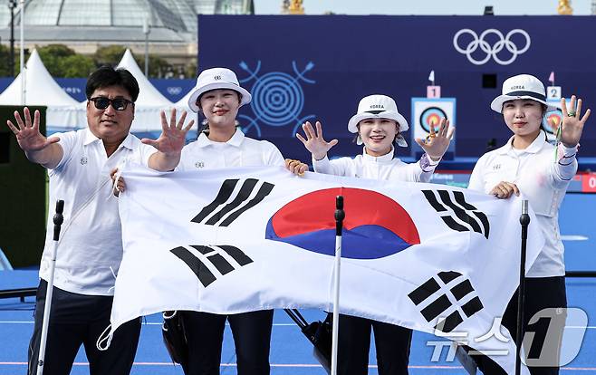 대한민국 양궁대표팀 임시현, 남수현, 전훈영, 양창훈 감독이 29일(한국시간) 프랑스 파리 레쟁발리드 특설 사로에서 열린 2024 파리올림픽 양궁 여자 단체전 중국과의 결승전에서 금메달을 획득한 후 태극기를 들어보이고 있다. 2024.7.29/뉴스1 ⓒ News1 이동해 기자