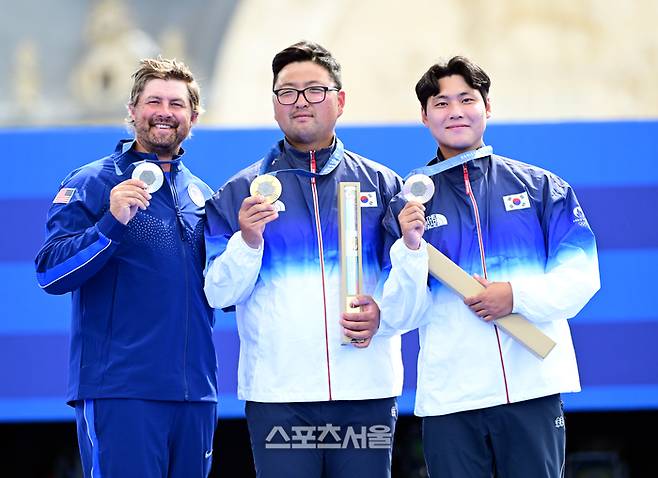 양궁 국가대표 김우진(가운데)이 4일(한국 시간) 프랑스 파리 앵발리드에서 열린 파리올림픽 양궁 남자 개인전 미국의 브래디 엘리슨과의 결승전에서 승리하며 3관왕을 달성한 뒤 메달리스트들과 함께 기념촬영을 하고 있다. 왼쪽부터 은메달 미국의 브래디 엘리슨, 금메달 김우진, 동메달 이우석. 김우진은 한국 선수 올림픽 역다 최다인 5개의 금메달을 획득했다. 2024. 8. 4.  파리 | 박진업 기자 upandup@sportsseoul.com