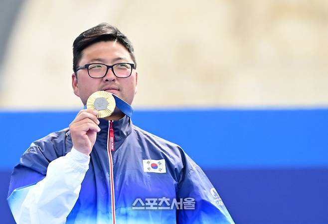 양궁 국가대표 김우진이 4일(한국 시간) 프랑스 파리 앵발리드에서 열린 파리올림픽 양궁 남자 개인전 미국의 브래디 엘리슨과의 결승전에서 승리하며 3관왕을 달성한 뒤 금메달을 들어보이고 있다. 김우진은 한국 선수 올림픽 역다 최다인 5개의 금메달을 획득했다. 2024. 8. 4.  파리 | 박진업 기자 upandup@sportsseoul.com