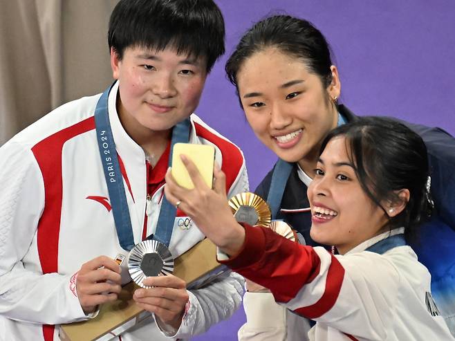 안세영이 5일(현지시각) 파리 라 샤펠 아레나에서 열린 2024 파리올림픽 배드민턴 여자 단식 결승전에서 중국 허빙자오와 경기에서 승리, 시상식에서 기념촬영을 하고 있다. 은메달을 딴 허빙자오는 오른손에 스페인 국기가 그려진 배지를 들고 있다. /올림픽사진공동취재단