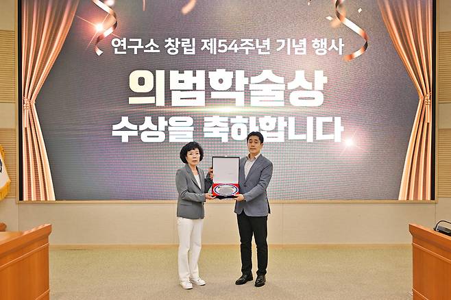 국방과학연구소 창립 54주년 기념식에서 고(故) 김용철 옹의 장녀인 김설매(왼쪽) 여사가 이수용(오른쪽) 선임연구원에게 상패를 전달하고 있다.[국방과학연구소 제공]