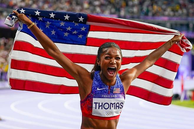 개브리엘 토머스(27‧미국)가 7일(한국시각) 2024 파리올림픽 육상 여자 200m 결선에서 금메달을 차지한 후 성조기를 들고 기뻐하고 있다. /UPI 연합뉴스