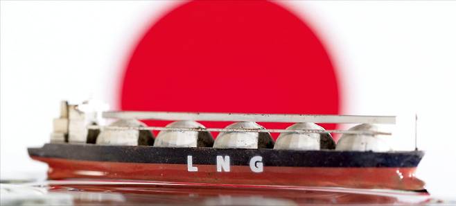2022년 5월 촬영된 사진에서 일본 국기 앞에 액화천연가스(LNG) 선박 모형이 놓여 있다.  로이터연합뉴스