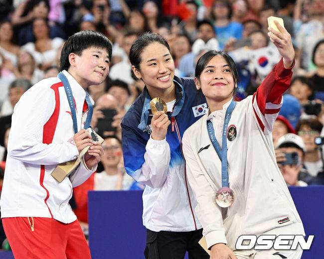 [OSEN=파리(프랑스), 최규한 기자] '셔틀콕 여제' 안세영(22, 삼성생명)이 꿈에 그리던 올림픽 금메달을 목에 걸었다.세계 랭킹 1위 안세영은&nbsp;5일 오후(한국시간) 프랑스 파리 포르트 드 라샤펠 경기장에서 열린 2024 파리올림픽 배드민턴 여자 단식 결승전에서 랭킹 9위 허빙자오(중국)를 2-0으로 꺾고 금메달을 획득 했다. &nbsp;금메달 한국 안세영(가운데)와 은메달 중국 허빙자오(왼쪽), 동메달 인도네시아 툰중과 기념사진을 찍고 있다. 2024.08.05 / dreamer@osen.co.kr