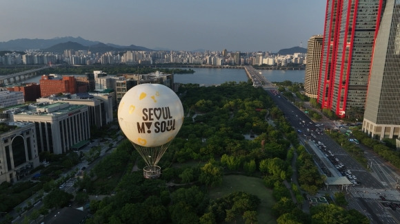 서울달 하늘 위로 두둥실 - 지난 6월 28일 서울 영등포구 여의도공원에서 열린 계류식 가스기구 서울달 프레스투어 행사에서 ‘서울달’이 비행을 하고 있다. 서울달은 오는 8월 22일까지 시범 운영을 한 뒤 23일 정식 개장해 유료 탑승으로 운영된다. 서울시 제공