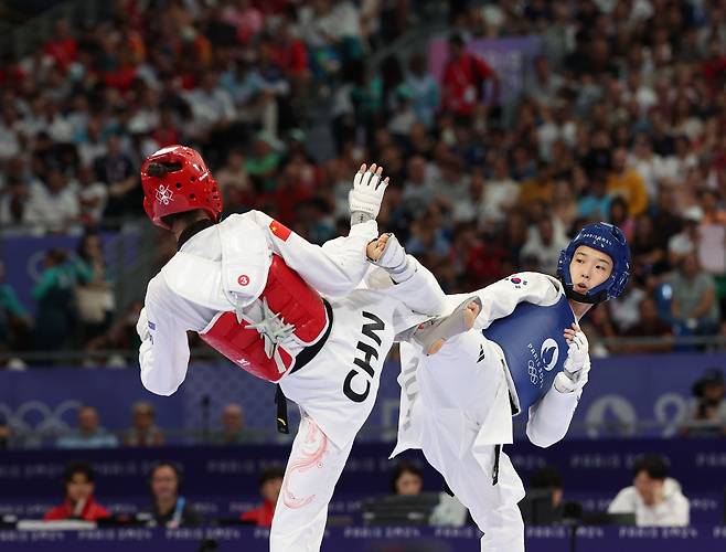 8일(현지 시각) 프랑스 파리 그랑팔레 태권도경기장에서 열린 2024 파리올림픽 태권도 여자 57kg급 준결승에서 한국 김유진이 '세계랭킹 1위'인 중국의 뤄쭝스와 경기를 펼치고 있다. /연합뉴스