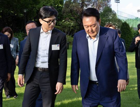 지난 7월24일 서울 용산 대통령실 앞 파인그라스에서 열린 국민의힘 신임 지도부 초청 만찬에서 윤석열 대통령이 국민의힘 한동훈(왼쪽) 대표 등 신임 지도부와 대화하며 이동하고 있다.<연합뉴스 사진>