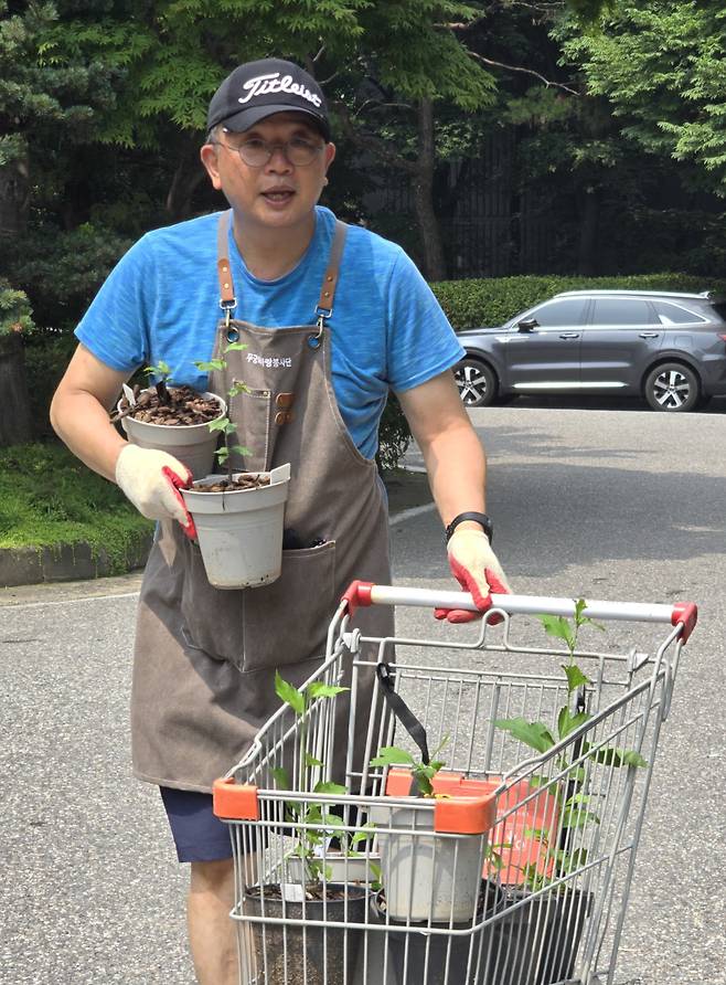 손수 화분에 키운 무궁화를 나눠주기 위해 손수레를 밀고 손에 들고 오는 조민제 변호사 표정이 싱글벙글하다. 이는 나눔이 만든 표정이다.