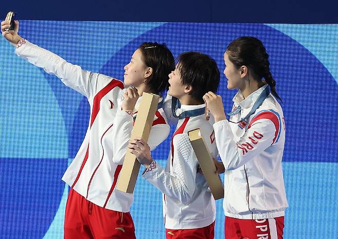 2024 파리올림픽 다이빙 여자 10m 플랫폼 결승에서 동메달을 딴 북한 김미래(오른쪽)가 시상식에서 메달리스트들과 사진을 찍고 있다. 연합뉴스