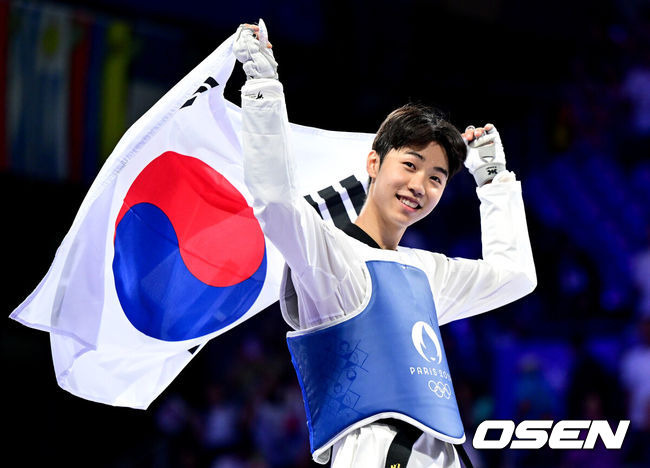 [OSEN=파리(프랑스), 최규한 기자] 8일(한국시간) 프랑스 파리 그랑팔레에서 ‘2024 파리올림픽’ 태권도 남자 58kg급 결승 한국 박태준과 아제르바이잔 가심 마고메도프의 경기가 열렸다.박태준은 마고메도프를 상대로 2-0으로 앞서다 상대가 부상으로 기권해 금메달을 따냈다.금메달을 거머쥔 박태준이 태극기를 펼치며 기뻐하고 있다. 2024.08.08 / dreamer@osen.co.kr