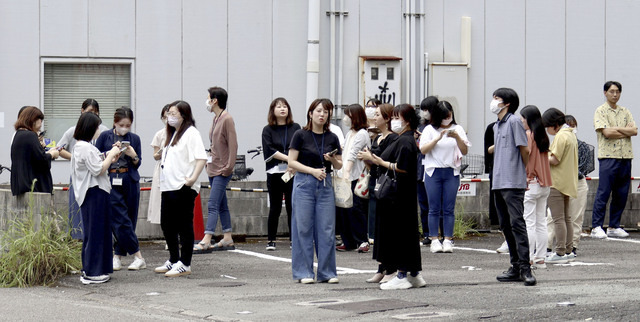 일본 규슈 미야자키현 주민들이 8일 인근 해역에서 규모 7.1의 지진이 발생하자 건물 밖으로 대피해 방재 정보를 확인하고 있다. AP연합뉴스