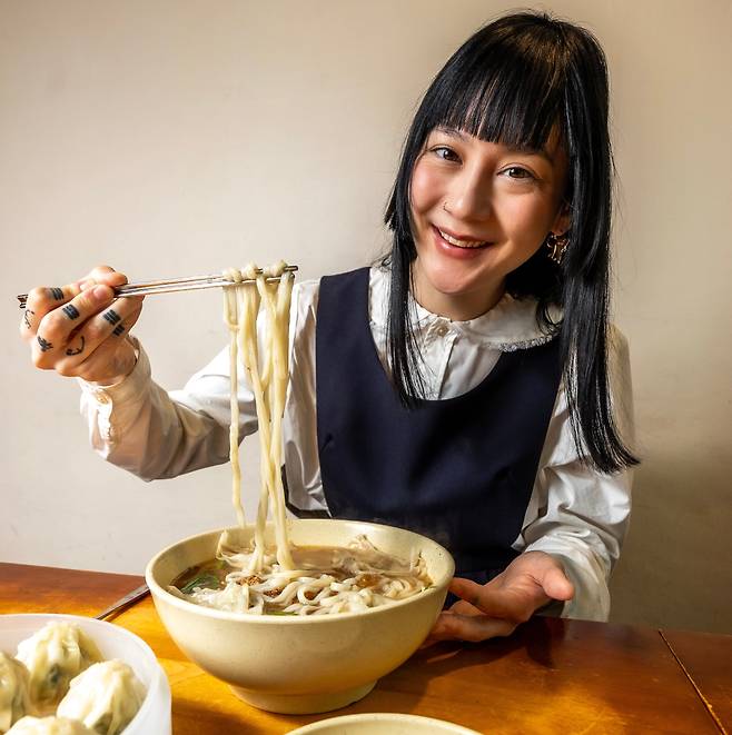 세계적 베스트셀러 ‘H마트에서 울다’를 쓴 미국 록가수 겸 작가 미셸 자우너가 지난 6일 서울 명동교자에서 칼국수와 만두를 맛보고 있다. 어릴 적 어머니를 따라 서울 올 때마다 찾던 식당이다. 손가락의 문신은 태극기의 건곤감리. /이신영 영상미디어 기자