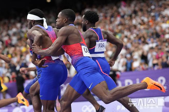 [파리=AP/뉴시스] 10일(한국시각) 프랑스 파리의 스타드 드 프랑스에서 열린 2024 파리 올림픽 육상 남자 400m 결승에서 미국 대표팀 첫 주자 크리스티안 콜먼이 두 번째 주자 케니 베드나렉에 배턴을 넘기기 위해 애쓰고 있다. 2024.08.10.