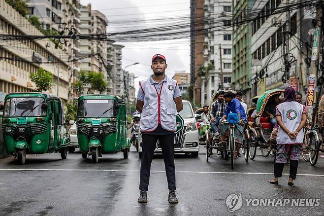 교통정리에 나선 방글라데시 청년들 (다카 AFP=연합뉴스) 지난 9일(현지시간) 방글라데시 수도 다카의 도로에서 청년들이 경찰을 대신해 교통정리에 나서고 있다. 2024.8.10. photo@yna.co.kr