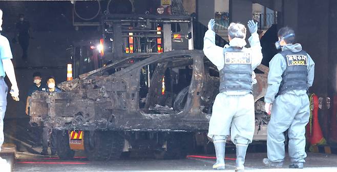 5일 인천 서구 아파트 지하 주차장 화재 현장에서 합동 감식을 마친 경찰이 화재가 발생한 전기차를 옮기고 있다. [연합]