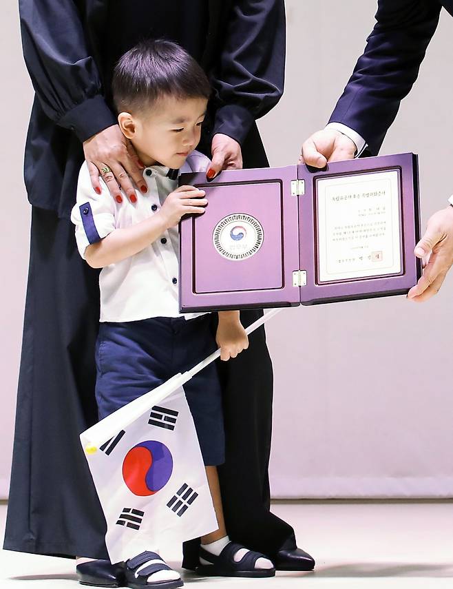 12일 오후 서울 서대문구 대한민국임시정부 기념관에서 열린 독립유공자 후손 국적증서 수여식에서 항일무장투쟁을 전개한 최찬식 선생의 후손 최 다닐 군이 박성재 법무부 장관으로부터 특별귀화증서를 전달받고 있다. 2024.8.12/뉴스1