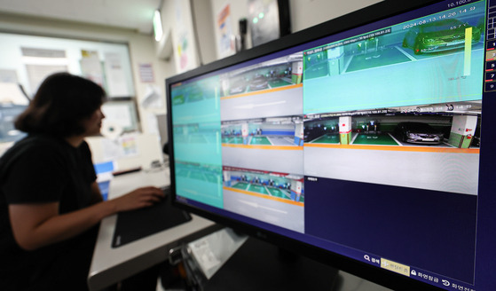 An official checks thermal cameras installed in an EV charging area in a public parking lot in southern Seoul on Tuesday. [NEWS1]