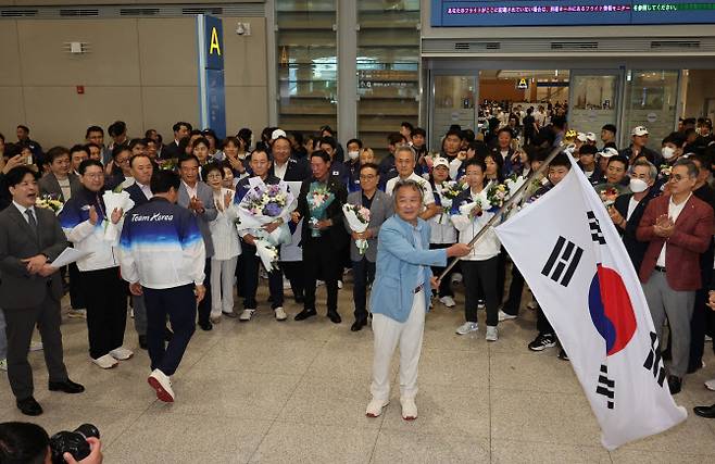 이기흥 대한체육회장이 13일 오후 인천국제공항 제2여객터미널을 통해 귀국해 태극기를 흔들고 있다. 사진=연합뉴스