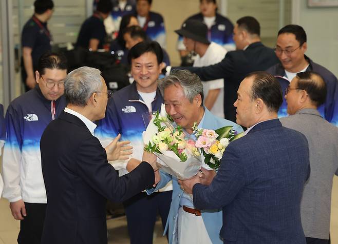 이기흥 대한체육회장이 13일 인천국제공항 제2여객터미널을 통해 귀국해 유인촌 문화체육관광부 장관과 인사를 나누고 있다. 사진 | 인천국제공항=연합뉴스