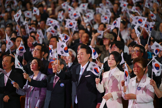 윤석열 대통령과 김건희 여사가 15일 서울 종로구 세종문화회관에서 열린 제79주년 광복절 경축식에서 태극기를 흔들고 있다. 연합뉴스