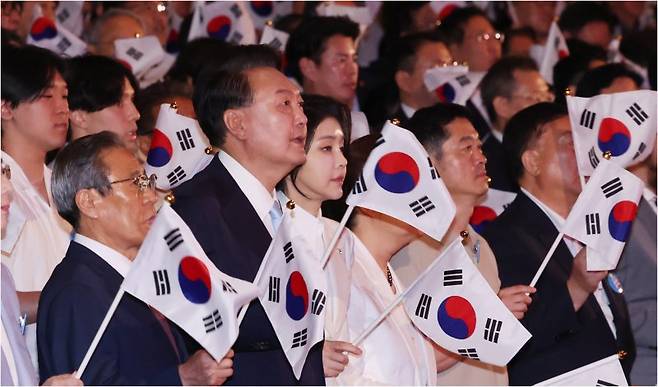 윤석열 대통령과 부인 김건희 여사가 15일 서울 종로구 세종문화회관에서 열린 제79주년 광복절 경축식에서 태극기를 흔들고 있다. 윤 대통령은 경축사에서 자유를 중시하되 질서와 규범이 전제돼야 한다는 점을 강조하면서 "선동과 날조로 국민을 편 갈라 그 틈에서 이익을 누리는 데만 집착하는 이들이 우리의 앞길을 가로막는 반자유세력, 반통일세력"이라고 강조했다. 연합뉴스